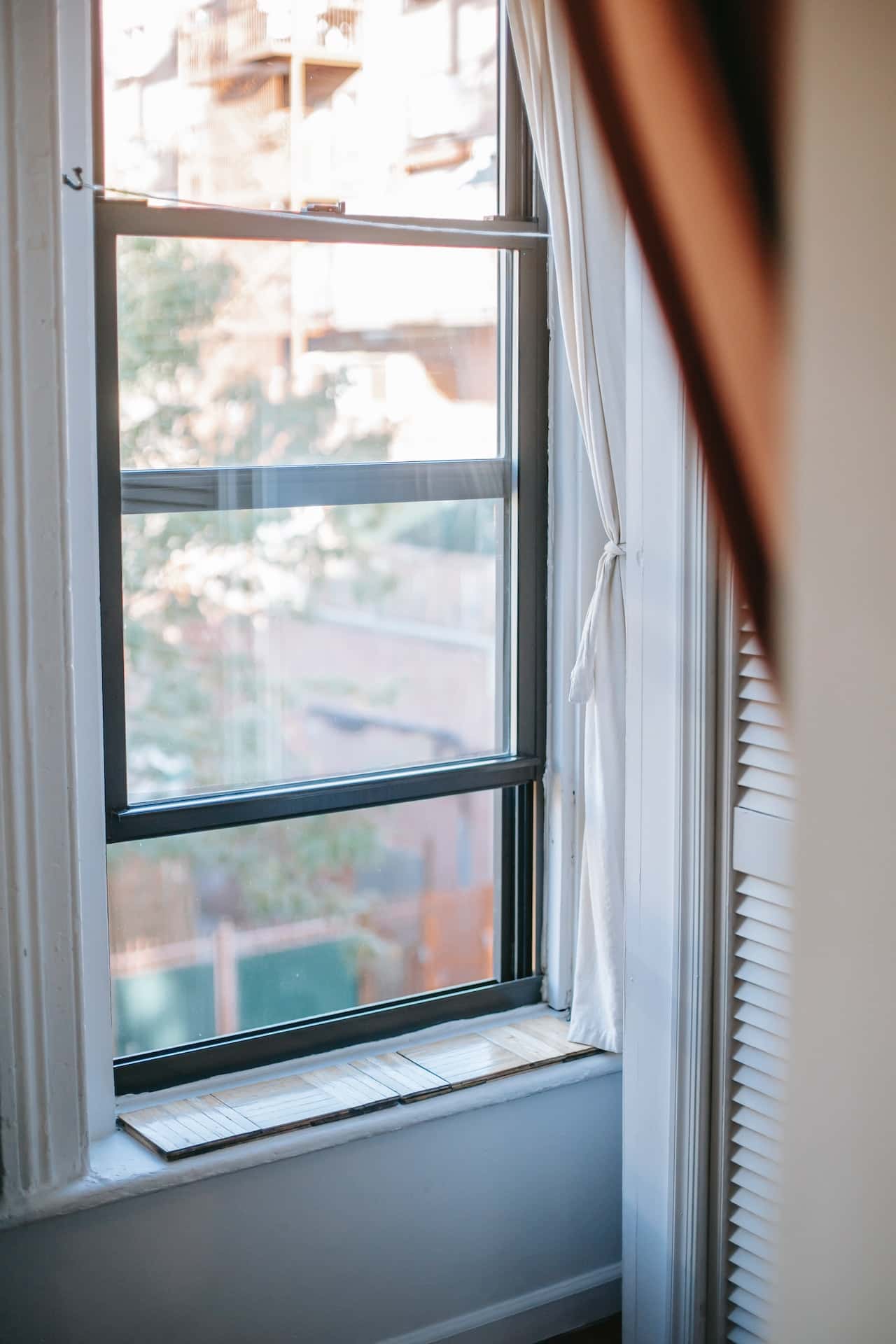Open sliding window grill design with soft daylight and urban view