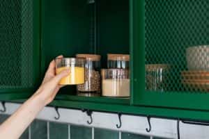 Woman Kitchen Taking Jar Out Of Cabinet