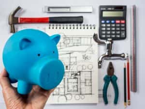 hand holding piggy bank over architecture