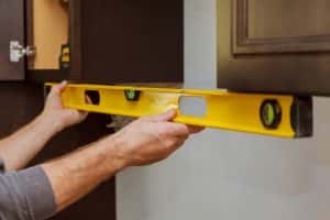 Rear View Serviceman Fixing Cabinet Kitchen