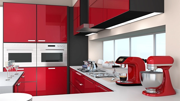 Bold modern kitchen cupboards in glossy red with silver appliances and matching red accessories