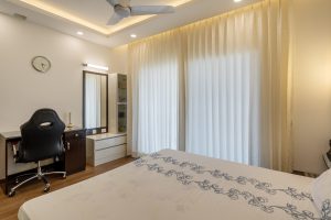 HomeLane modern bedroom interior with study desk, dressing table, and neutral decor