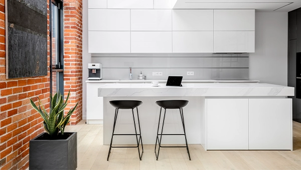Minimalist modern kitchen cupboards in all white with marble island and exposed brick wall