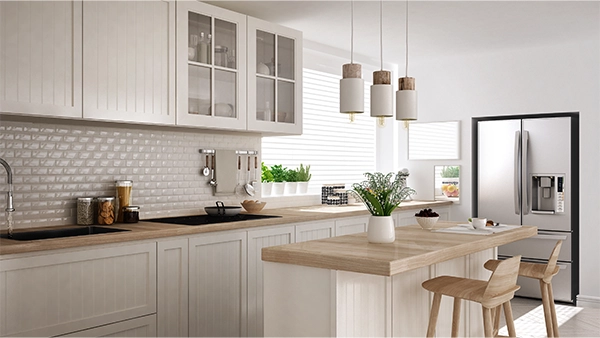 Bright kitchen triangle layout with island seating sink and fridge in a cozy white space