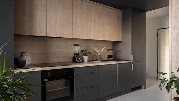 Compact modern kitchen cupboards in matte grey with built in appliances and wood accents