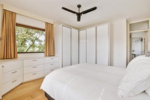 White corner wardrobe design with drawers for small modern bedroom 