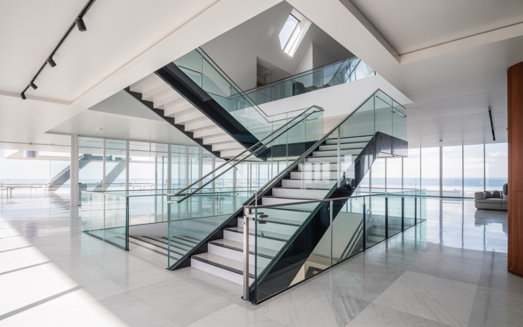 Elegant modern steel staircase design with glass railings in a luxury open space