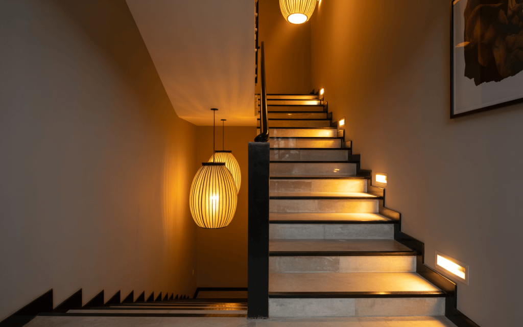 Elegant modern luxury staircase design with ambient step lighting and pendants