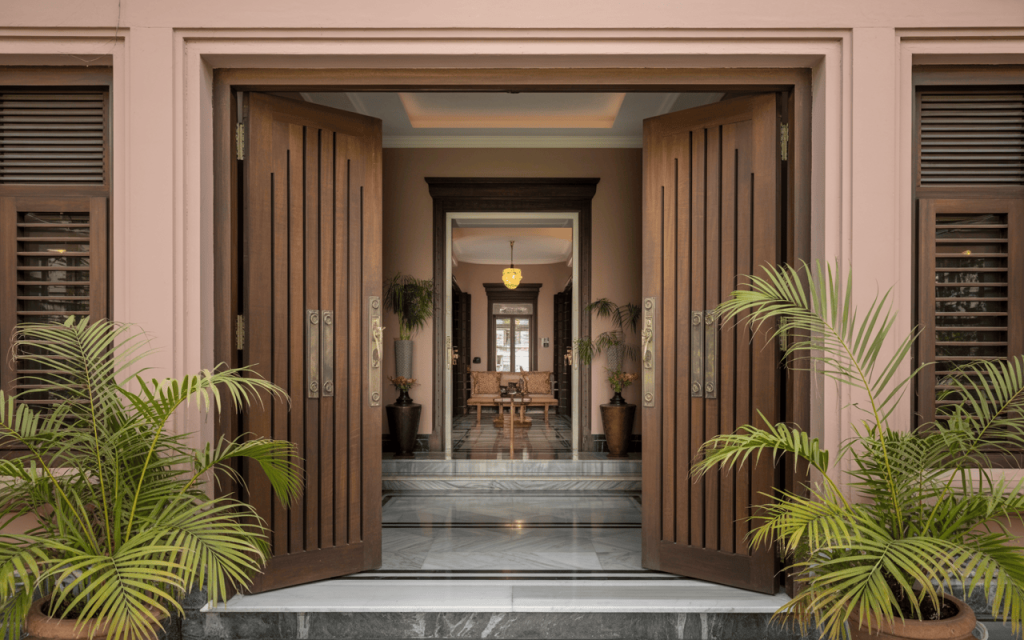 Traditional simple main double door design with vertical grooves and brass handles