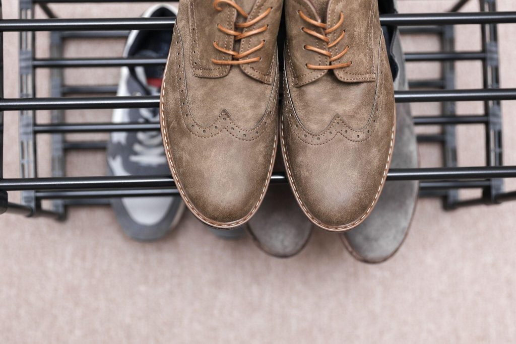 Close-up metal shoe rack design holding formal leather shoes in organized setup