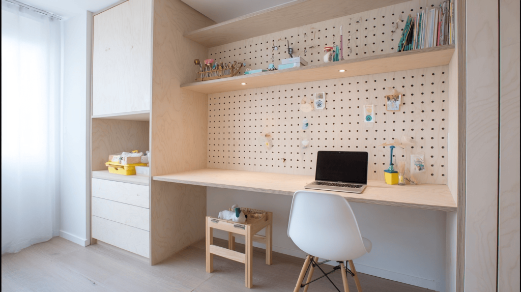 Modern computer table design with wooden pegboard wall and minimal workspace setup