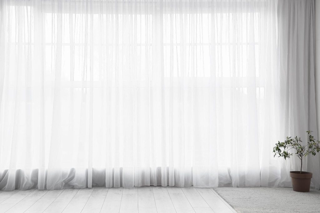 Elegant modern bedroom curtain ideas featuring sheer white drapes for airy interiors