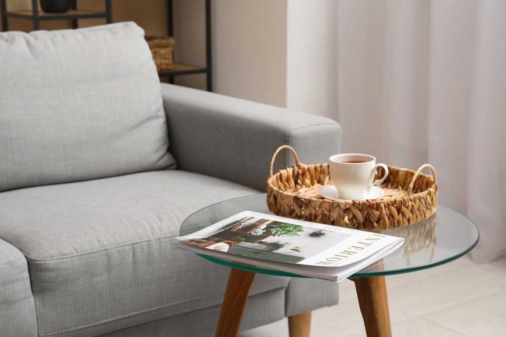 Elegant glass tea table design with modern decor and cozy reading corner setup
