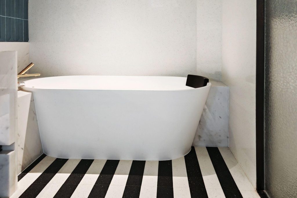 Chic 2026 bathroom tile trends featuring bold black and white striped floor design