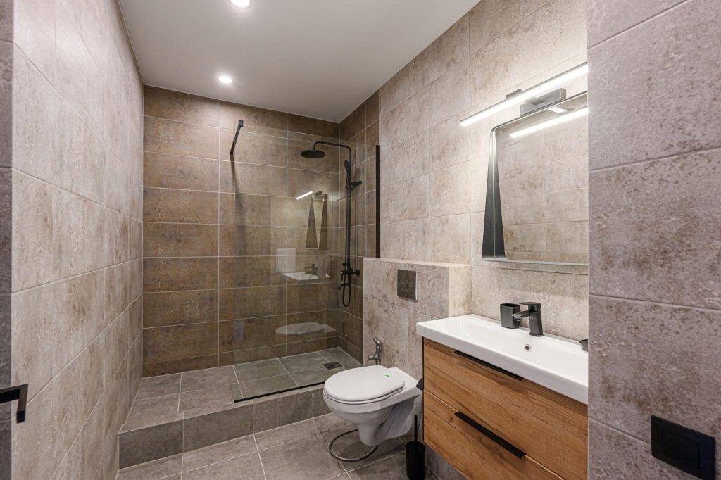 Stylish master bathroom tile trends with walk-in shower, stone tiles and modern vanity
