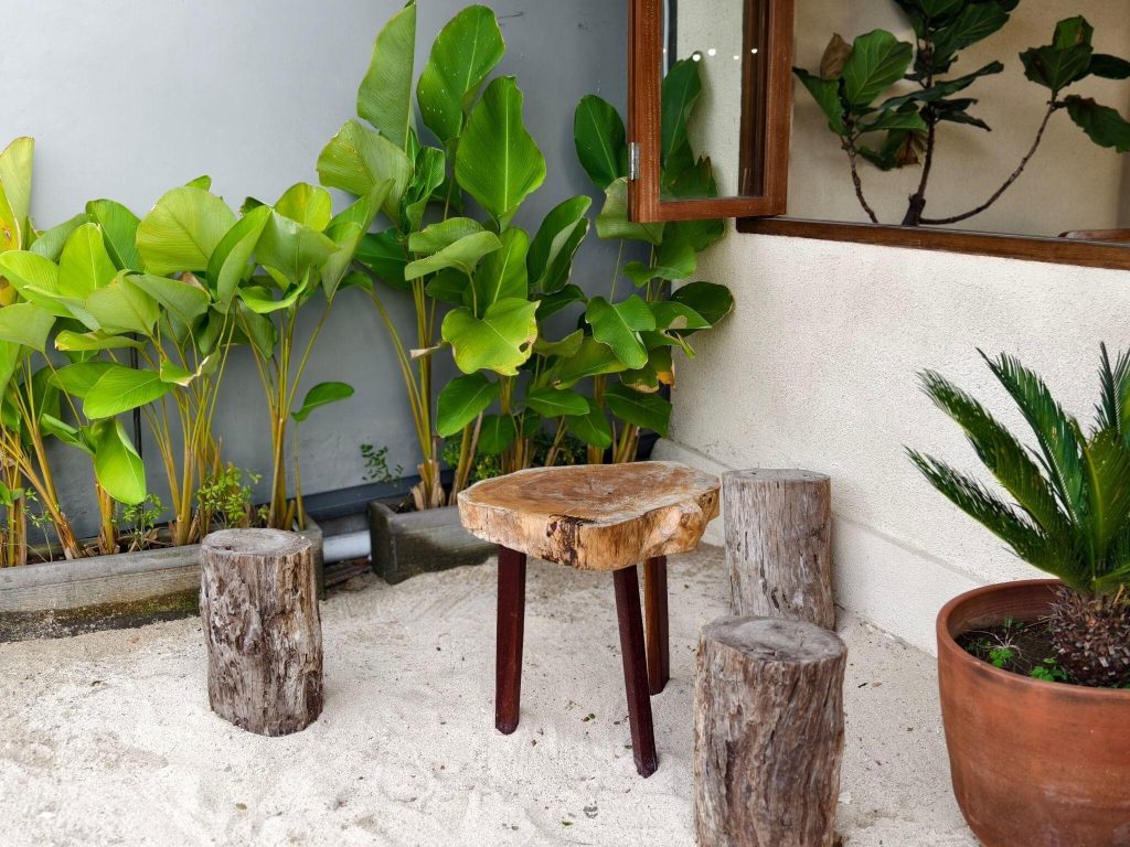 Natural furniture design trends 2026 showcasing rustic wooden stools in a green space