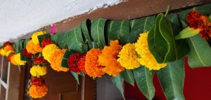 Elegant Gudi Padwa celebration at home toran with mango leaves and marigold garland decor