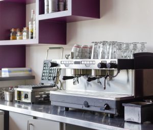 Modern cafe style kitchens with espresso machine, glassware and sleek coffee counter setup