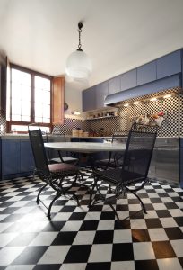 Elegant cafe style kitchens with checkered flooring, dining setup and vintage blue cabinets design