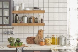 Cafe style kitchens with white tiles, wooden shelves and styled countertop storage decor