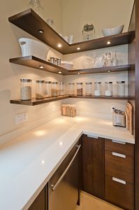 Modular kitchen corner units with open wooden shelves, glass jars, and smart space saving design