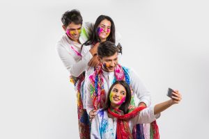 Trendy party ideas for holi with white outfits, colorful gulal and festive group styling