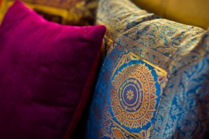 Vibrant party ideas for holi decor with colorful cushions and traditional embroidered patterns