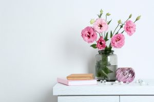 Elegant party ideas for holi decor with pink flowers, vase, and minimal festive setup