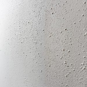 Close-up textured wall designs in off-white plaster finish with subtle grain and matte natural surface