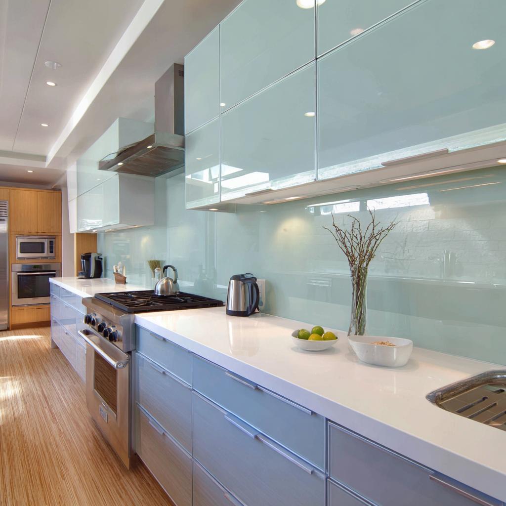 Sleek back painted glass kitchen backsplash with glossy aqua finish and modern cabinets