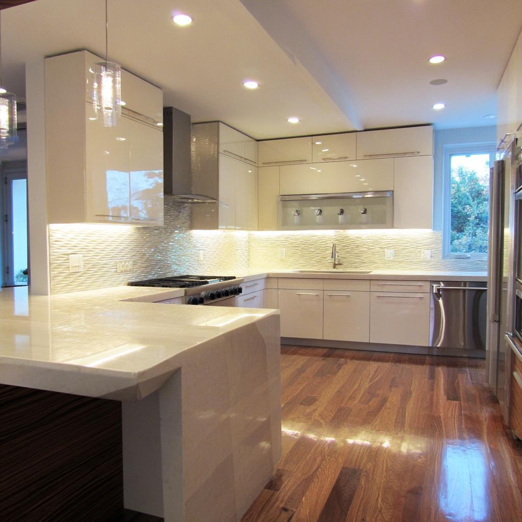 Premium back painted glass kitchen cabinets with glossy white finish and warm lighting