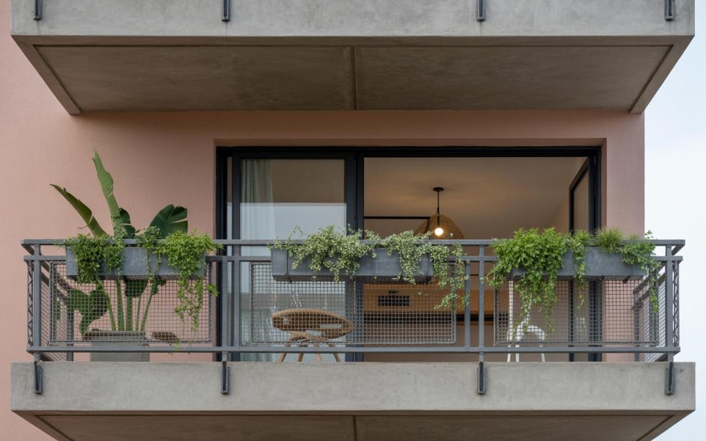 Modern simple iron railing design for balcony featuring mesh panels with plants and minimalist exterior