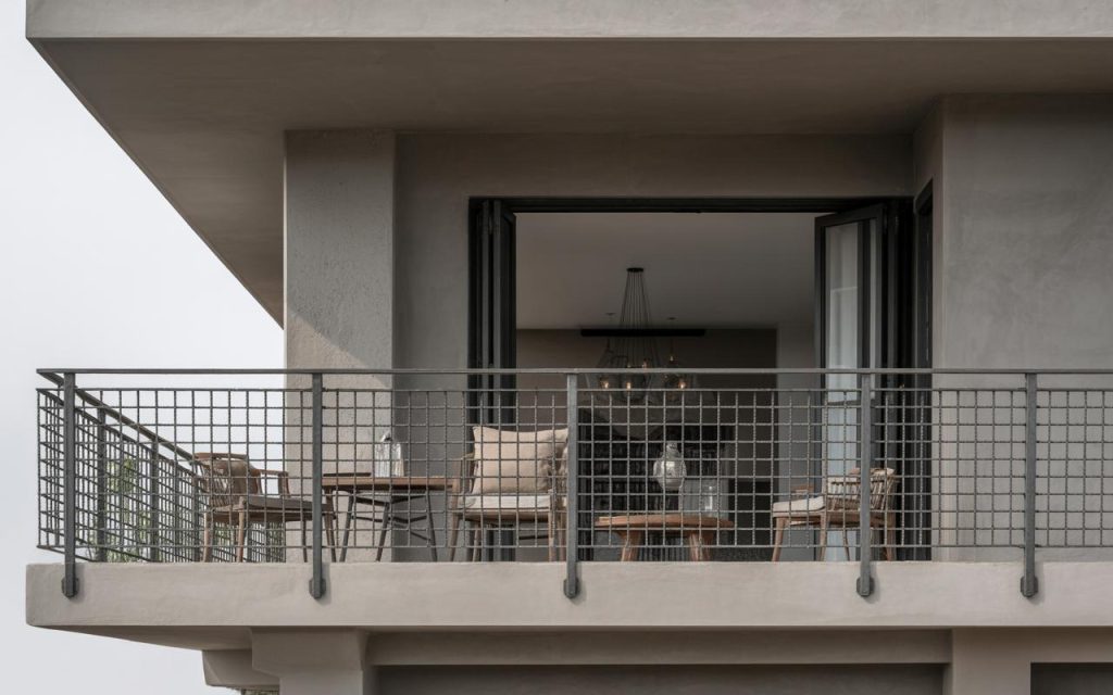 Minimal balcony railing design iron featuring grid pattern metal bars with modern outdoor seating