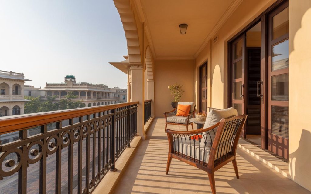 Elegant iron railing design for balcony featuring decorative scrollwork and cozy outdoor seating