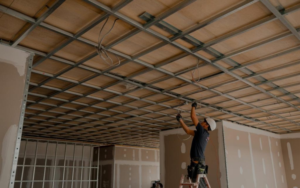 Professional false ceiling installation with metal grid framework and wiring setup in progress