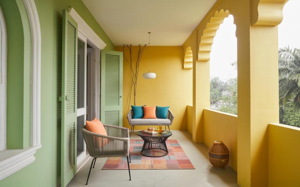 Vibrant Home vastu balcony with yellow walls, seating and decor enhancing positive energy flow