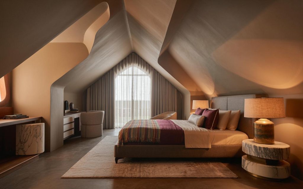 Stylish bedroom design for attic space with sloped ceiling and cozy bed layout