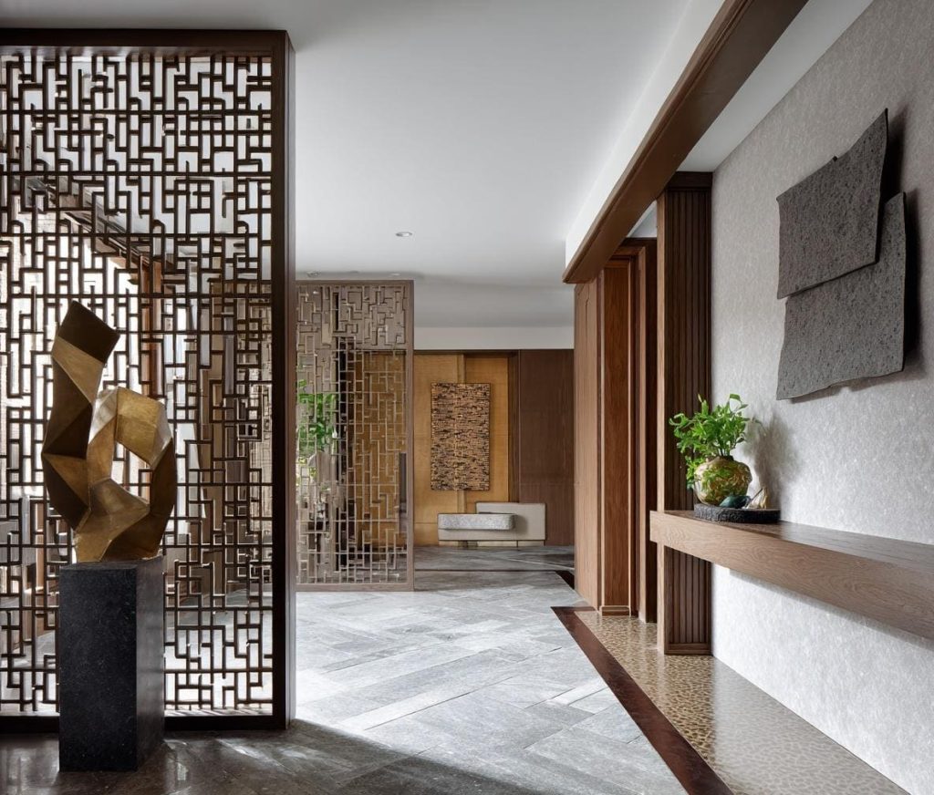Intricate jali style wooden partition for living room separating the foyer and hallway.