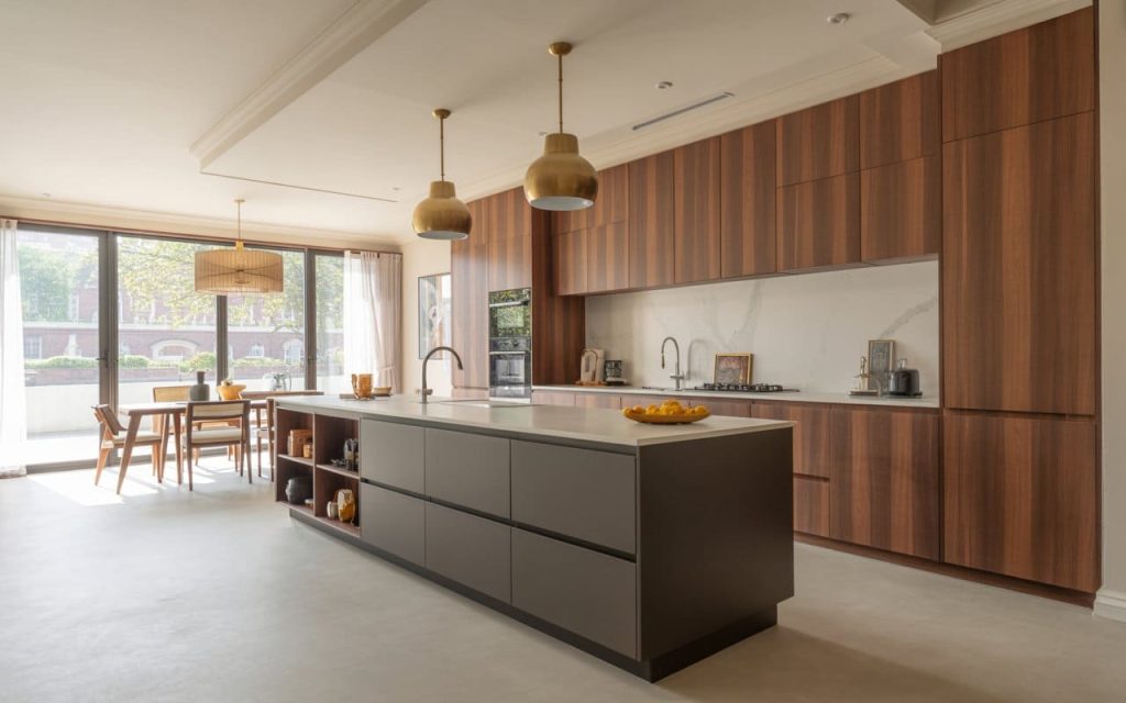 A spacious kitchen interior design featuring a dark grey island and wooden cabinetry.