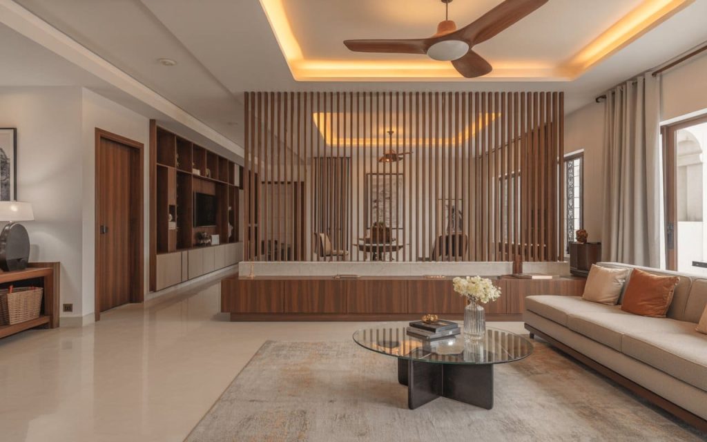 A vertical slatted wooden partition for living room separating a lounge and dining area.
