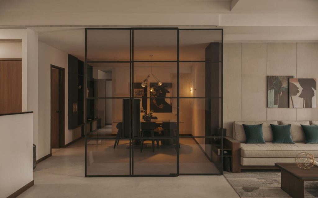 A sleek, transparent glass partition for living room separating the lounge and dining.