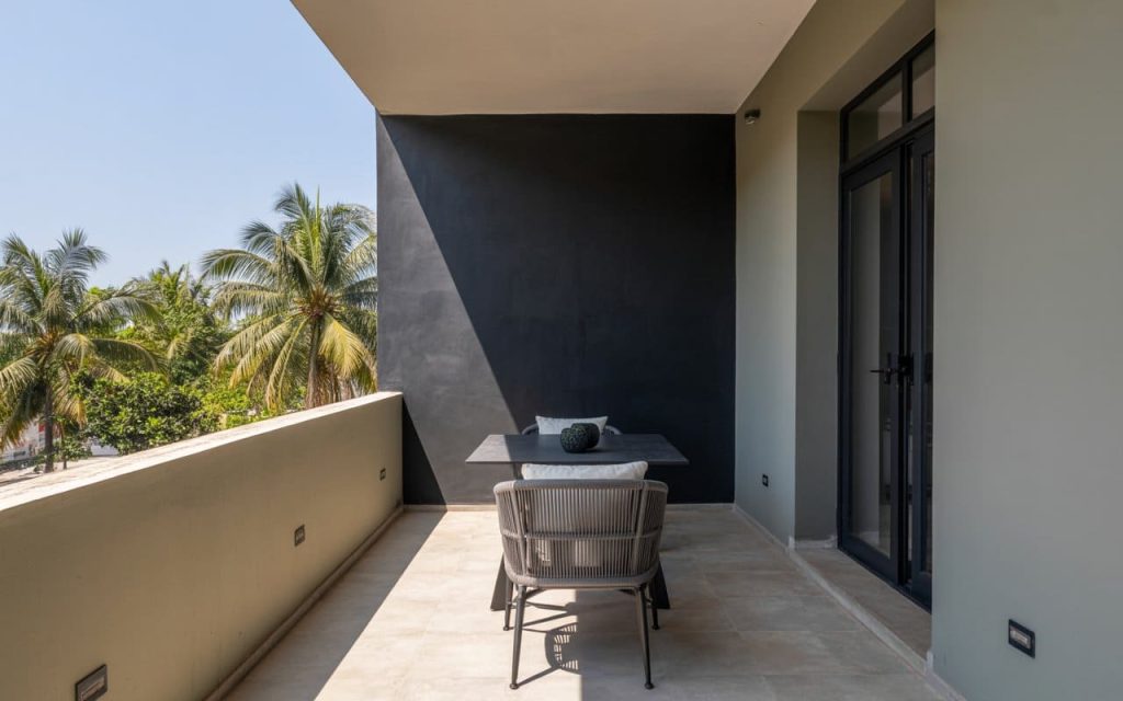Modern balcony colour design featuring a bold black accent wall and grey seating area.