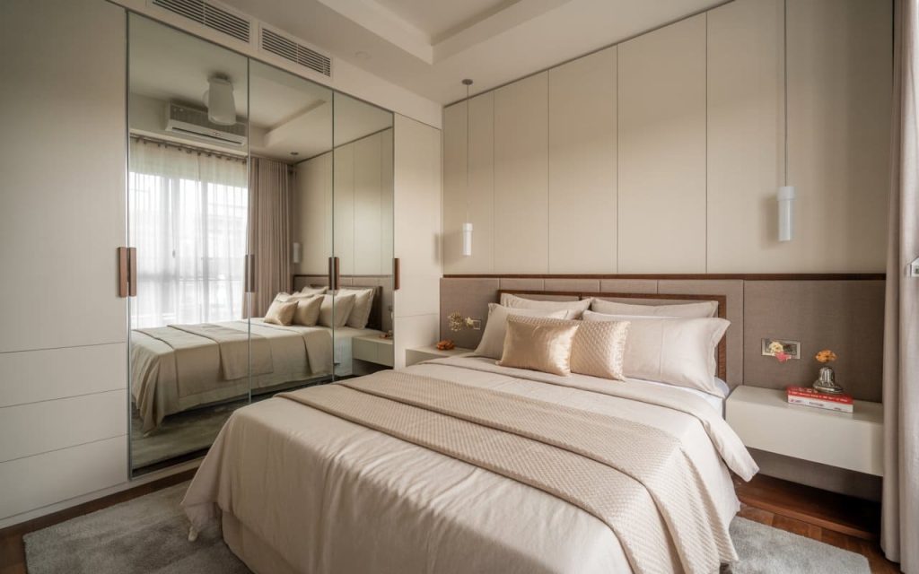 Serene bedroom wall design with beige panels, mirrored wardrobe, bed, and lights.