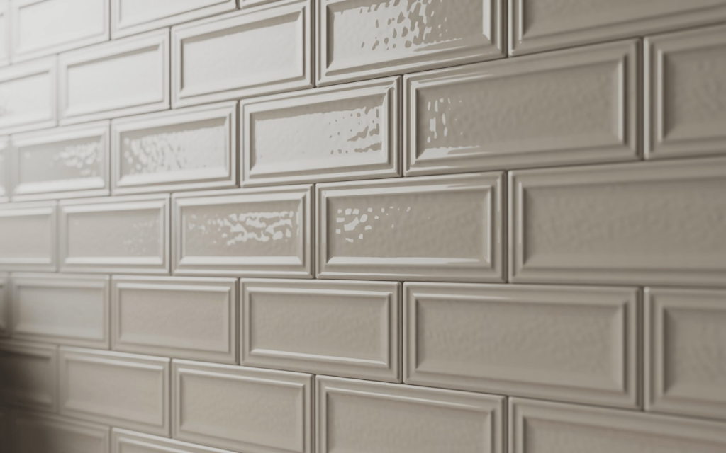 Close-up of glossy beige subway tile with a beautiful bevelled edge and reflective surface.