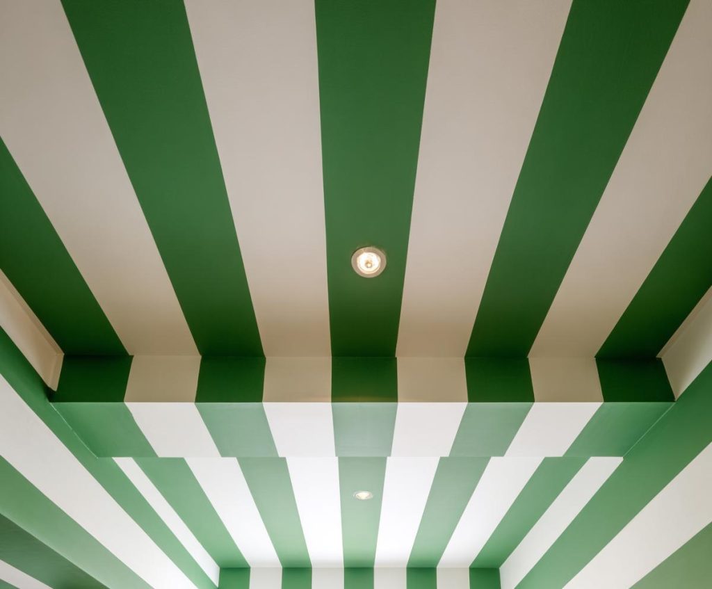 Striped sage green and white pop and wall colour combination with recessed spotlighting.