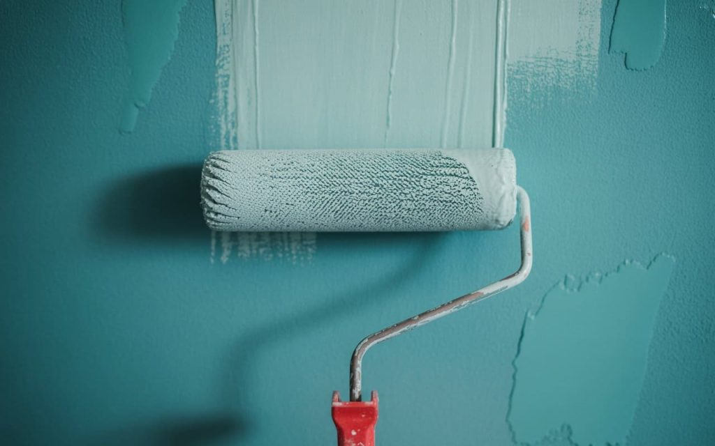 roller applying acrylic paint on interior wall