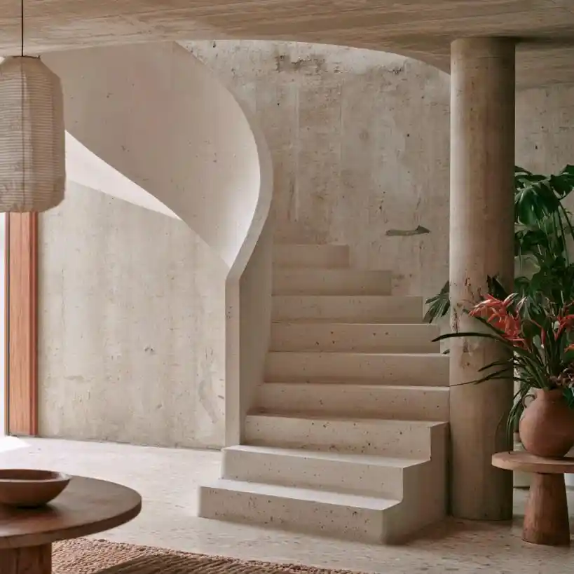  Curved concrete staircase in warm-toned interior