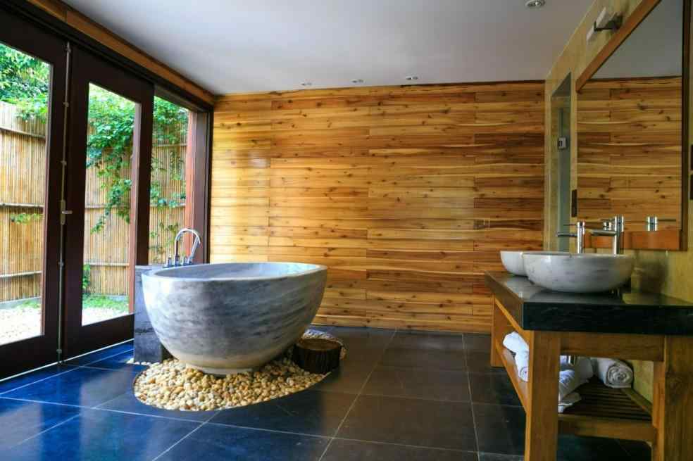 Wood panel wall bathroom with concrete tub