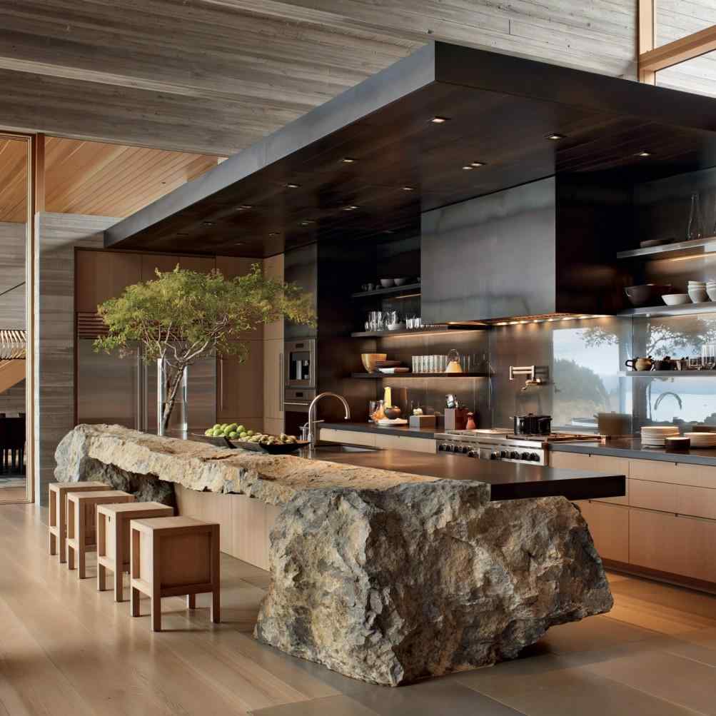 Unusual kitchen design with natural boulder island